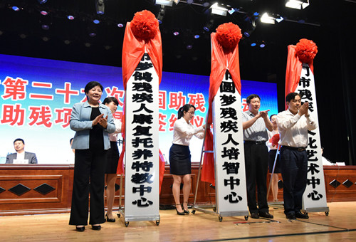 图为中央政策研究室综合局局长吴永发、省残联党组书记、理事长陶慧芬、市委书记别必雄分别为荆门市残疾人文化艺术中心、荆门市圆